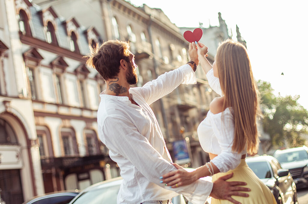 A couple holding a heart cutout, capturing the romantic spirit of the many things to do in Prague for couples.