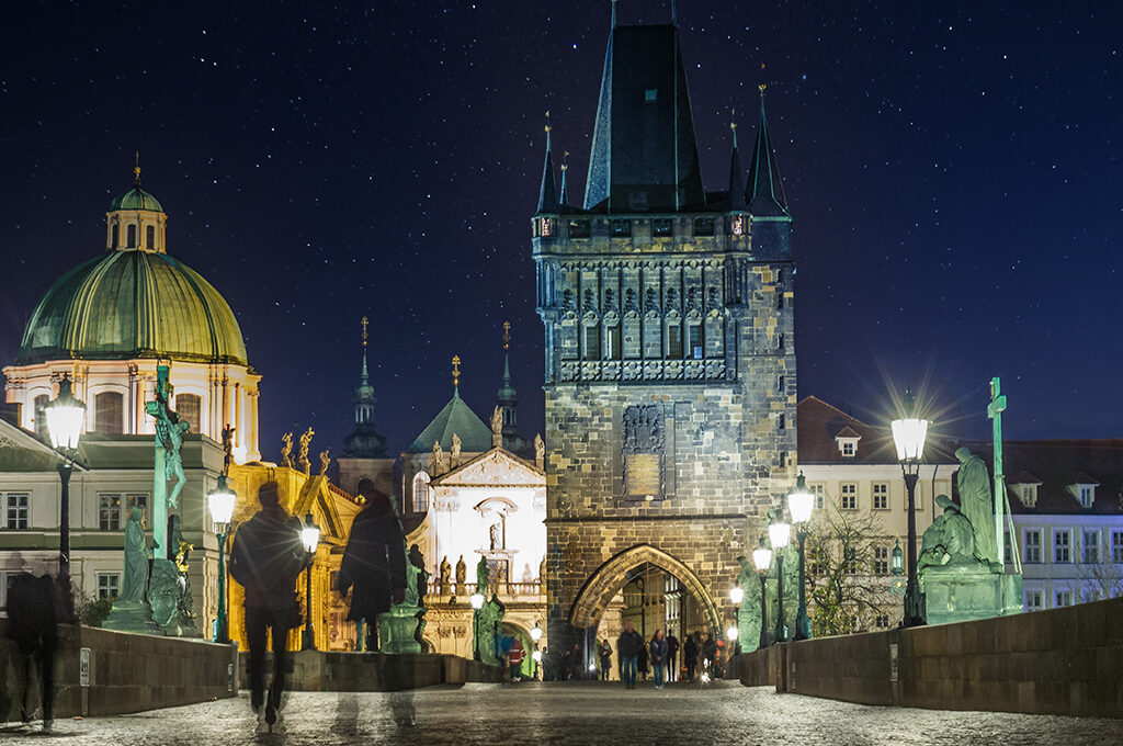Nighttime view of the historic Charles Bridge tower, one of the most romantic things to do in Prague for couple