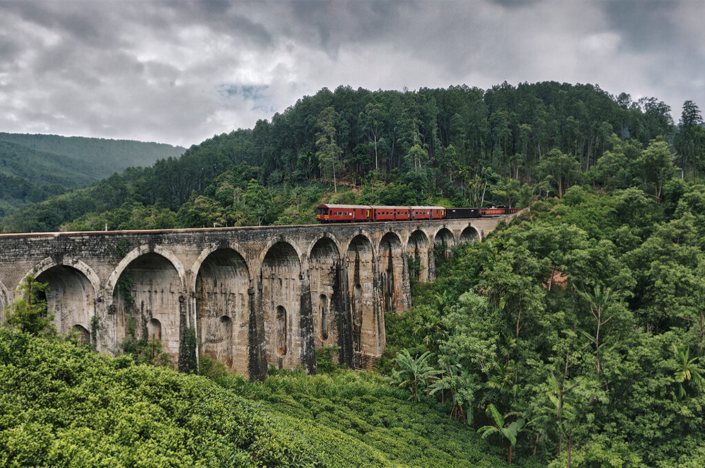 A train journey crossing the lush hills over the Nine Arch Bridge, one of the many safe and popular transport experiences to consider when evaluating is sri lanka safe for solo female travellers.