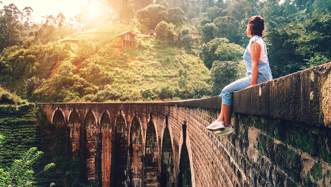 A solo female traveller enjoying a view from the iconic Nine Arch Bridge, showcasing the scenic and rewarding experiences that lead many to ask is sri lanka safe for solo female travellers.