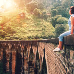 A solo female traveller enjoying a view from the iconic Nine Arch Bridge, showcasing the scenic and rewarding experiences that lead many to ask is sri lanka safe for solo female travellers.