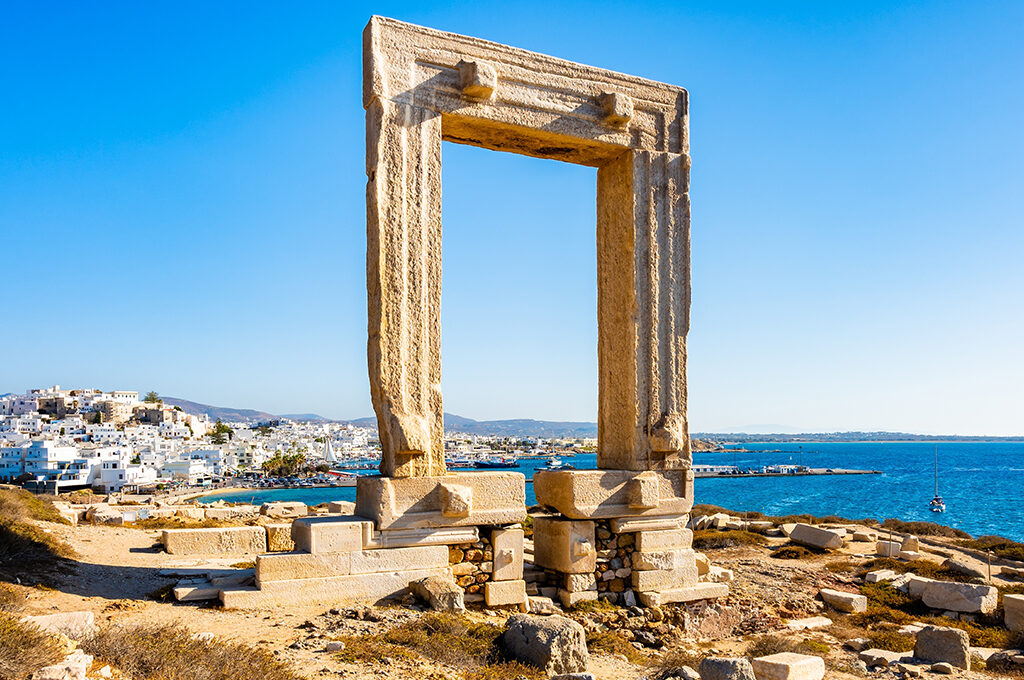 Ancient stone doorway framing a coastal town and deep blue sea view in Greece is one of the most popular holiday destinations.