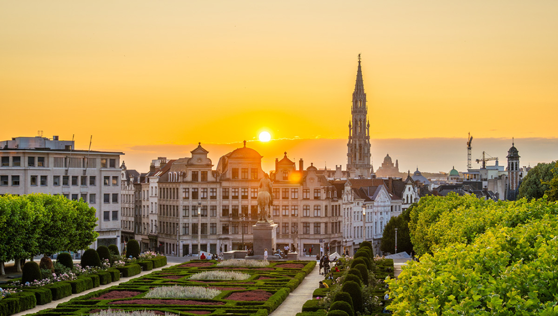 A panoramic sunset view of a lush green park in Brussels City Center, offering a scenic perspective for travelers deciding where to stay in Brussels.