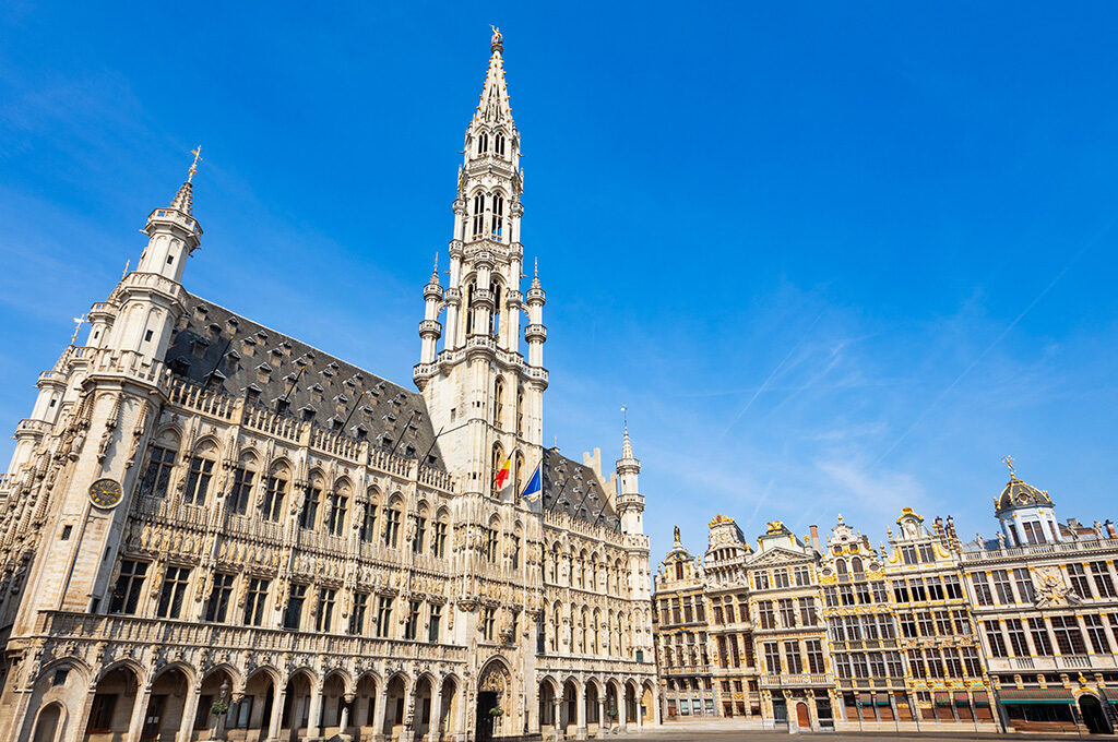 A bustling perspective of the historic Grand Place square, showcasing ornate guild houses and serving as a central hub for anyone researching where to stay in brussels.