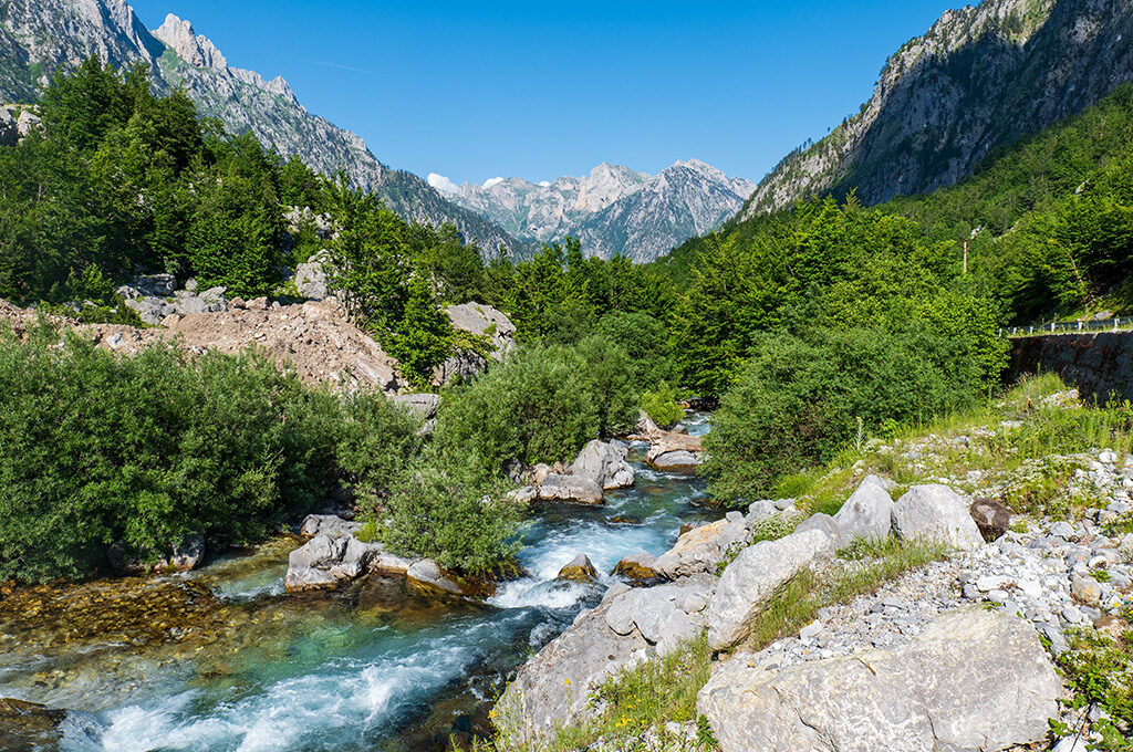 Dramatic, rugged peaks of the Accursed Mountains in the Albanian Alps under a bright sky, a must-visit region for outdoor enthusiasts looking near the best places to stay in Albania.