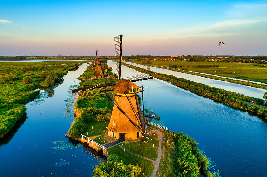 Aerial view of working windmill at Kinderdijk UNESCO site - calm alternative places to visit in Netherlands with family with direct water bus access from Rotterdam.