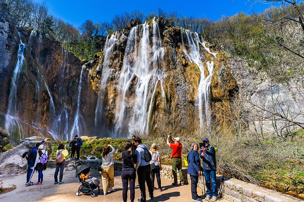 Tourists admiring cascades at Plitvice Lakes, a must-see natural attraction near the best Eastern European cities to visit.