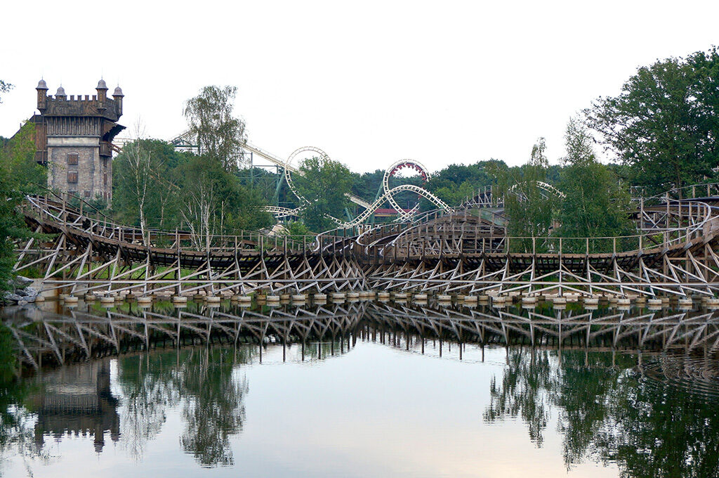 Wooden rollercoaster and fairytale castle at Efteling theme park - must-see places to visit in Netherlands with family featuring fairytale theming for all ages.