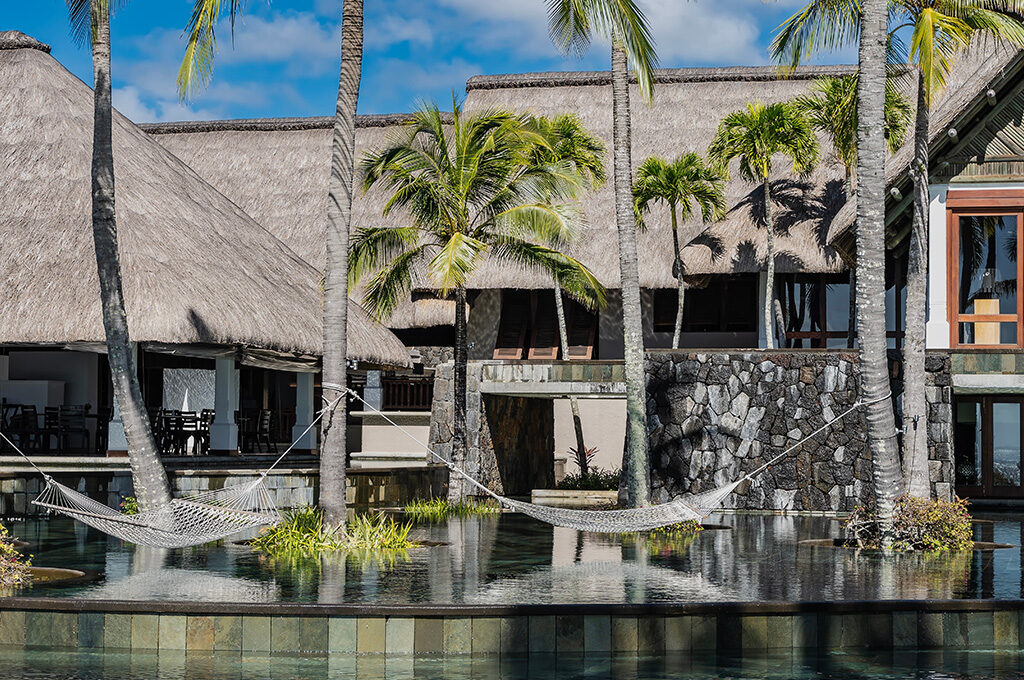 Relaxing hammocks suspended over a reflective pool at a luxury luxury resort among the best hotels in mauritius.