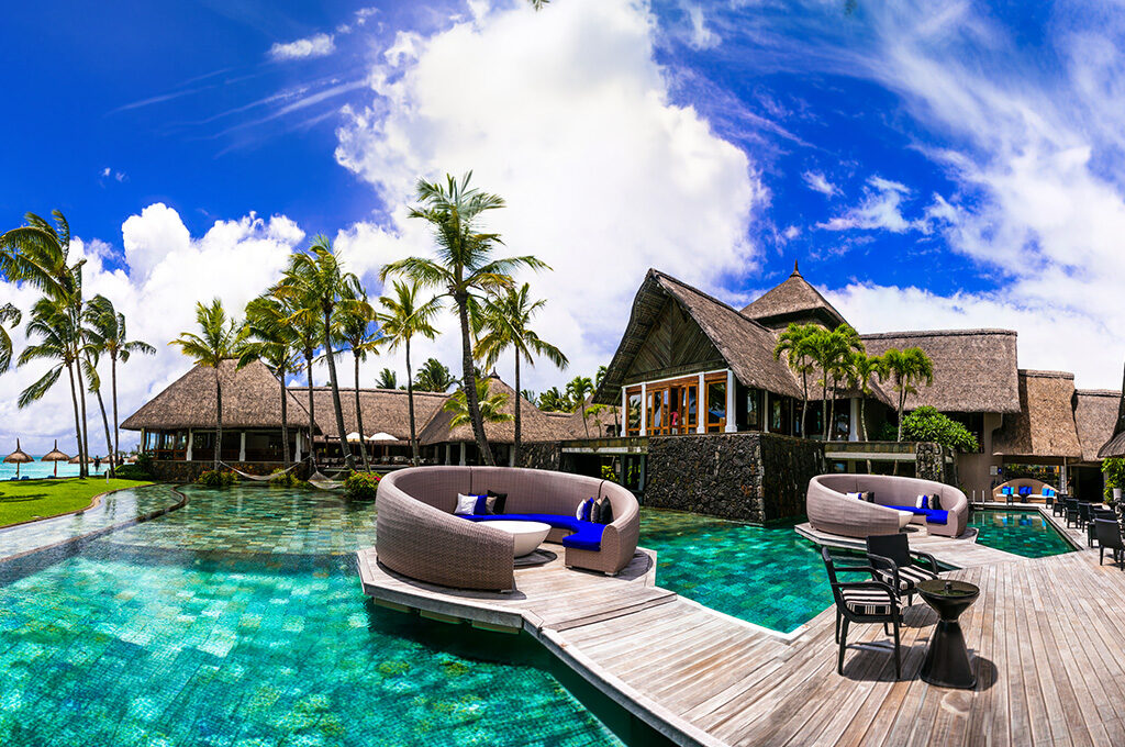 Tropical resort courtyard with circular lounge seating and swimming pools featured in the best hotels in mauritius.