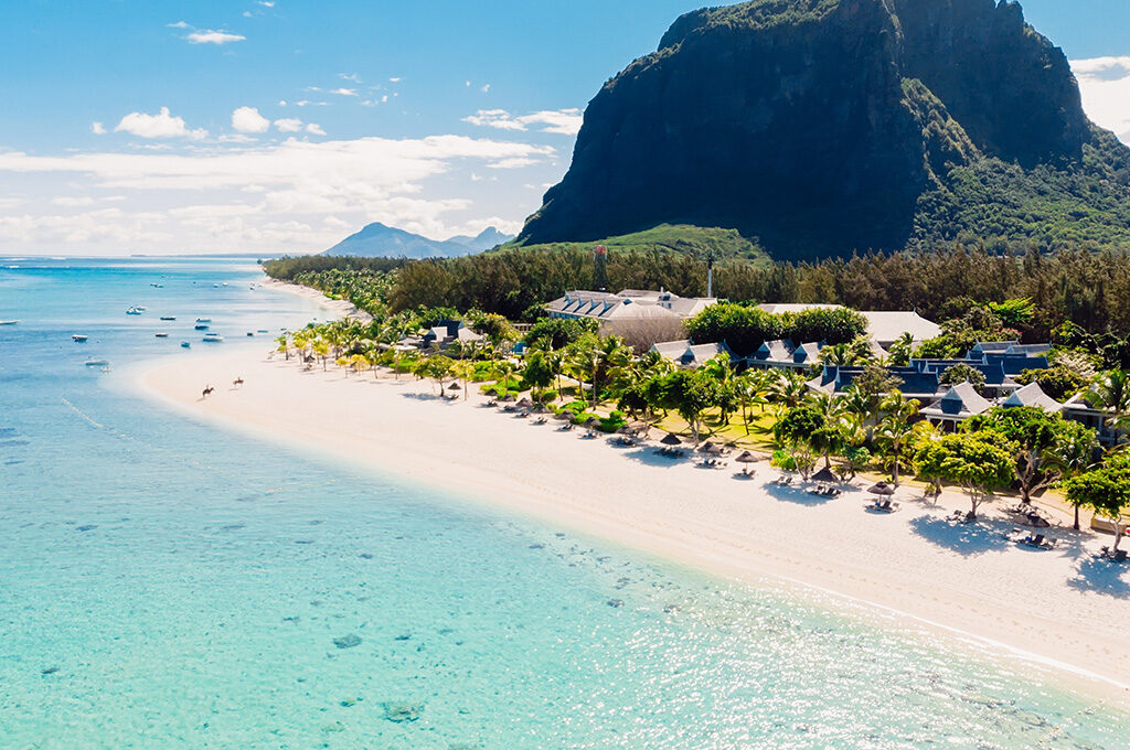 Panoramic aerial view of white sand beach and beachfront villas at the best hotels in mauritius under Le Morne.